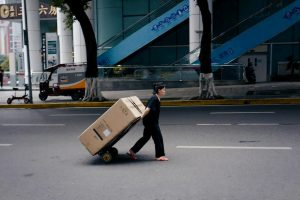 woman in black shirt and black pants walking on sidewalk during daytime